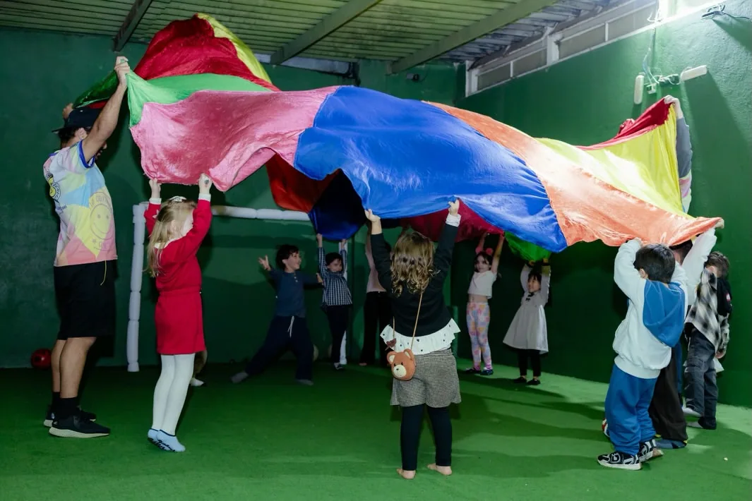 Recreação com paraquedas colorido na quadra
