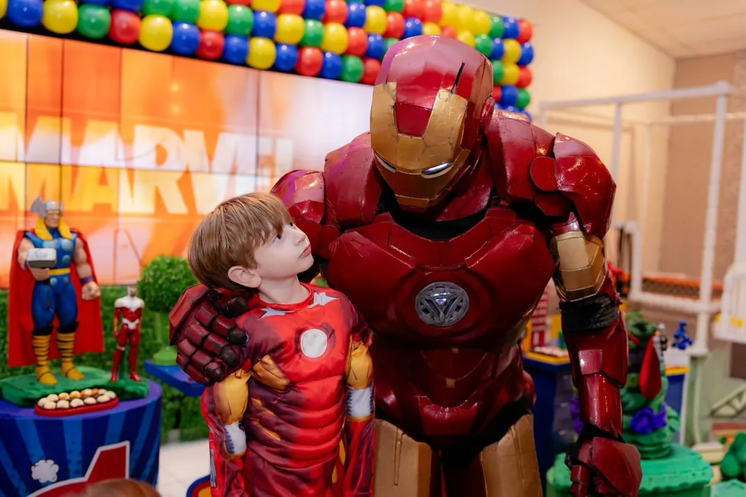 Antônio com o personagem do Homem de Ferro e a decoração ao fundo